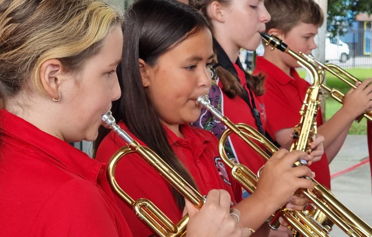 4 students in school uniform playing their wind instruments